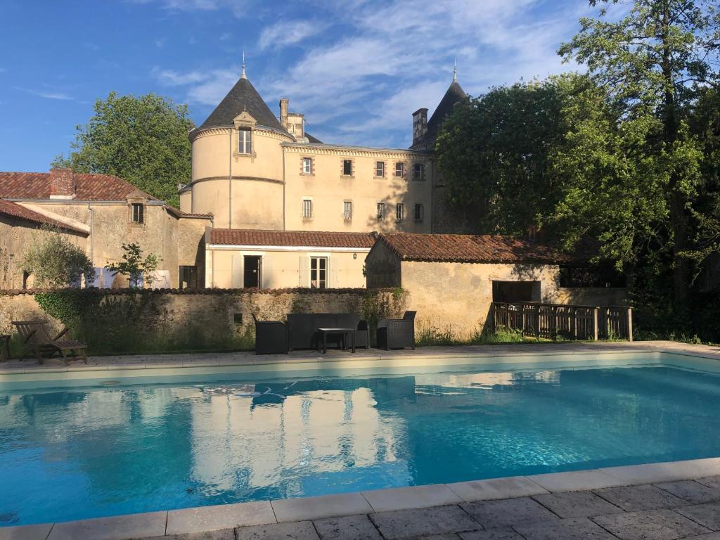 uma piscina em frente a um castelo em Château de la Mothe em Saint-Sulpice-en-Pareds