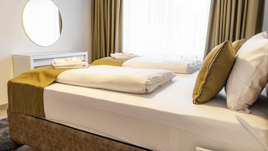 two beds in a hotel room with a window at E&B Apartments Waiblingen in Waiblingen