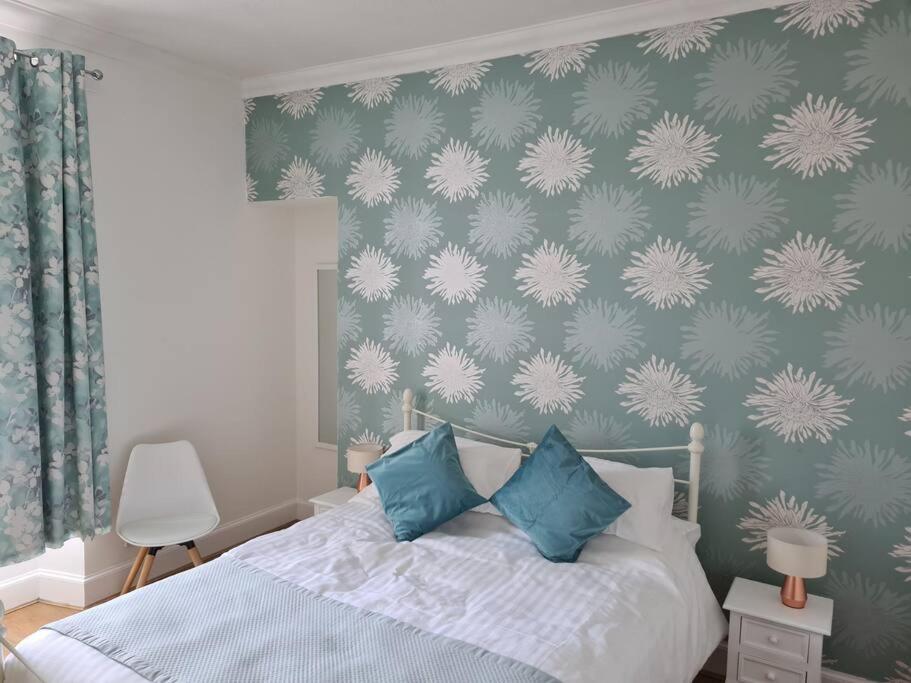 a bedroom with a bed with blue and white pillows at Cosy home in Stornoway