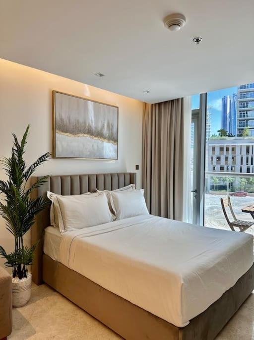 a bedroom with a large white bed and a balcony at Stunning Studio in Business Bay in Dubai