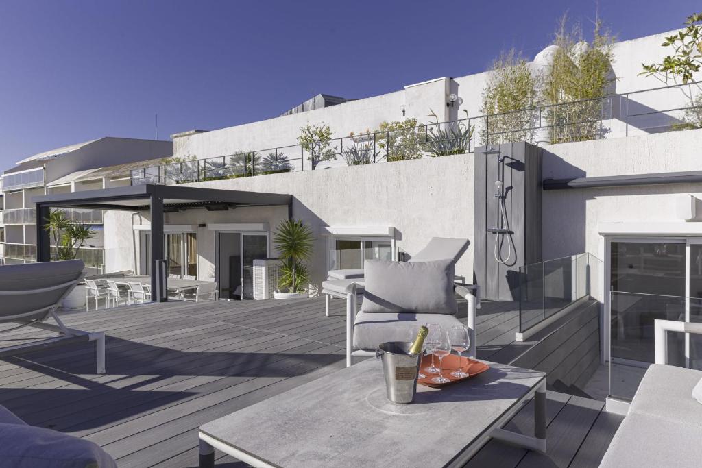 - une terrasse avec une table et des chaises dans un bâtiment dans l&#39;établissement Luxury Penthouse Montfleury, à Cannes