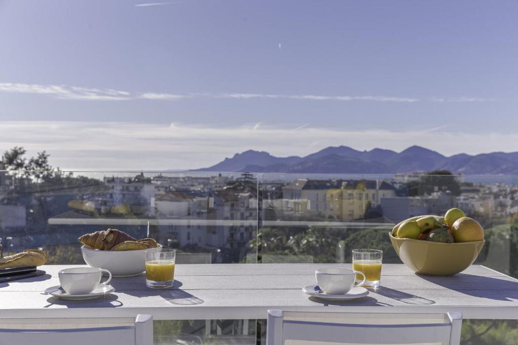 - une table avec un bol de fruits et deux verres de jus d&#39;orange dans l&#39;établissement Luxury Penthouse Montfleury, à Cannes