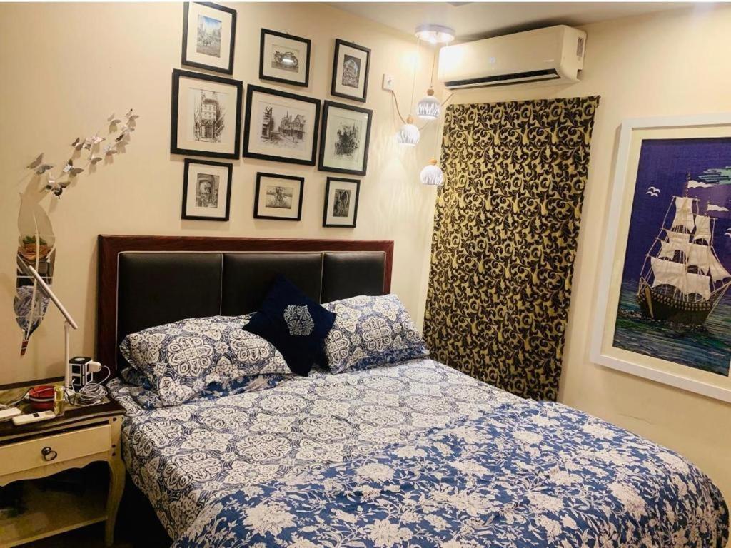 een slaapkamer met een bed en foto's aan de muur bij Entire One Bedroom Furnished Apartment in Islamabad