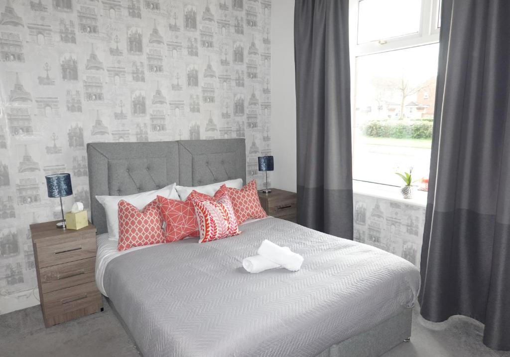 a bedroom with a bed with red and white pillows at Mossend Apartment by Klass Living Bellshill in Mossend