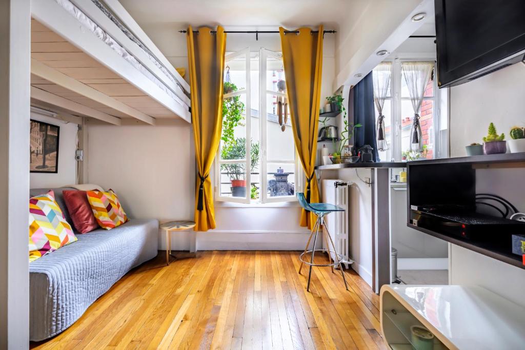 un salon avec un canapé et une fenêtre dans l'établissement Studio calme proche Tour Eiffel, à Paris