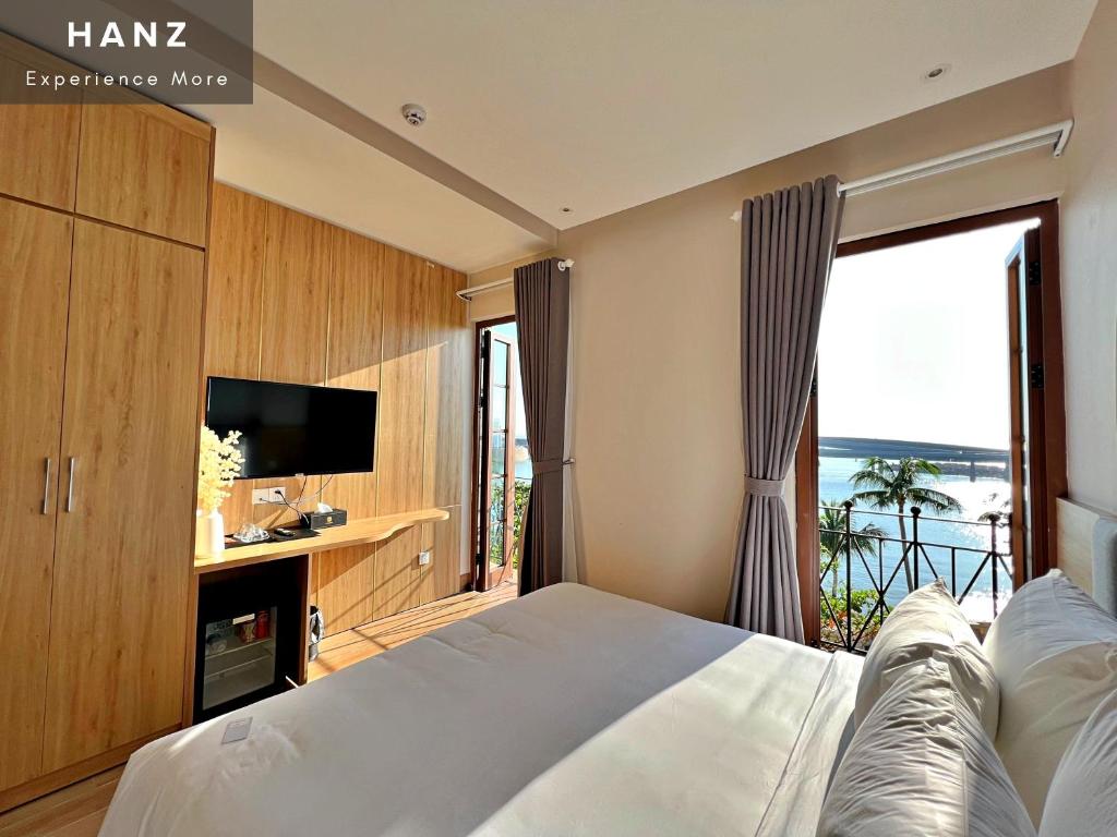 a bedroom with a bed and a large window at HANZ Lagoon Sunset Boutique Hotel in Phu Quoc