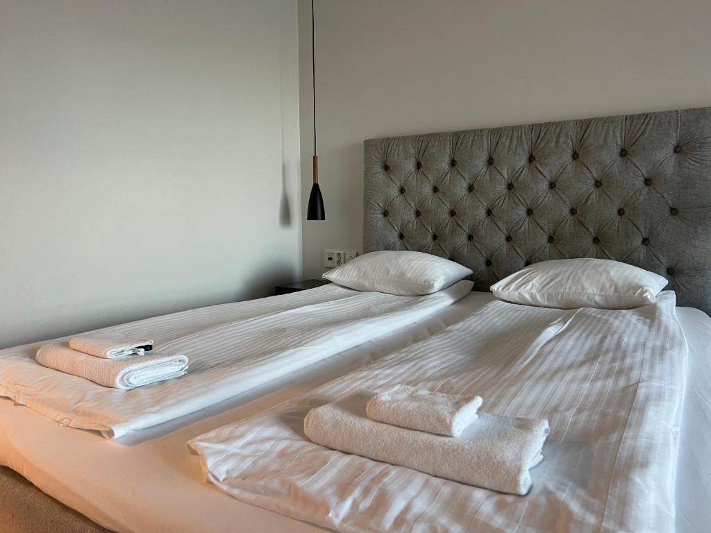 a bedroom with a bed with two towels on it at Kodikas keskustayksiö autohallipaikalla in Turku