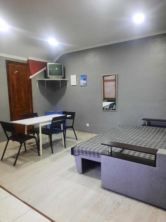 um quarto com uma cama, uma mesa e cadeiras em Мини-гостиница em Kamianets-Podilskyi