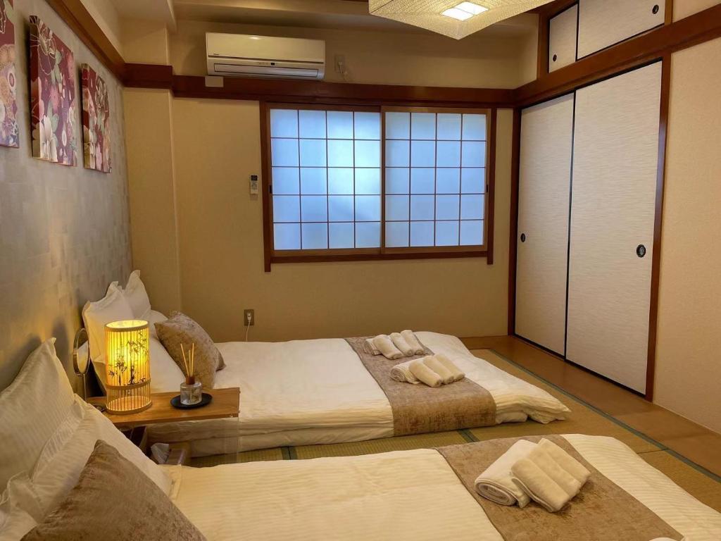 a bedroom with two beds and a window at 悦然民宿 in Osaka