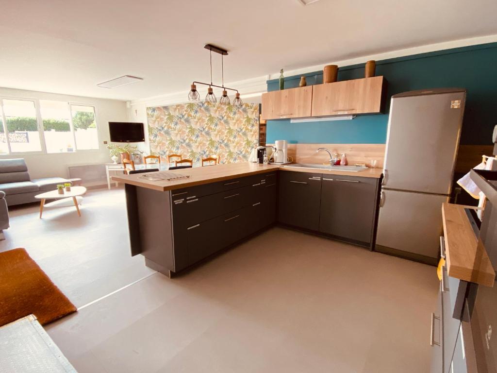 a kitchen with a refrigerator and a table in a room at Gite pour pros entre Niort et Fontenay &#47; Tout compris in Benet