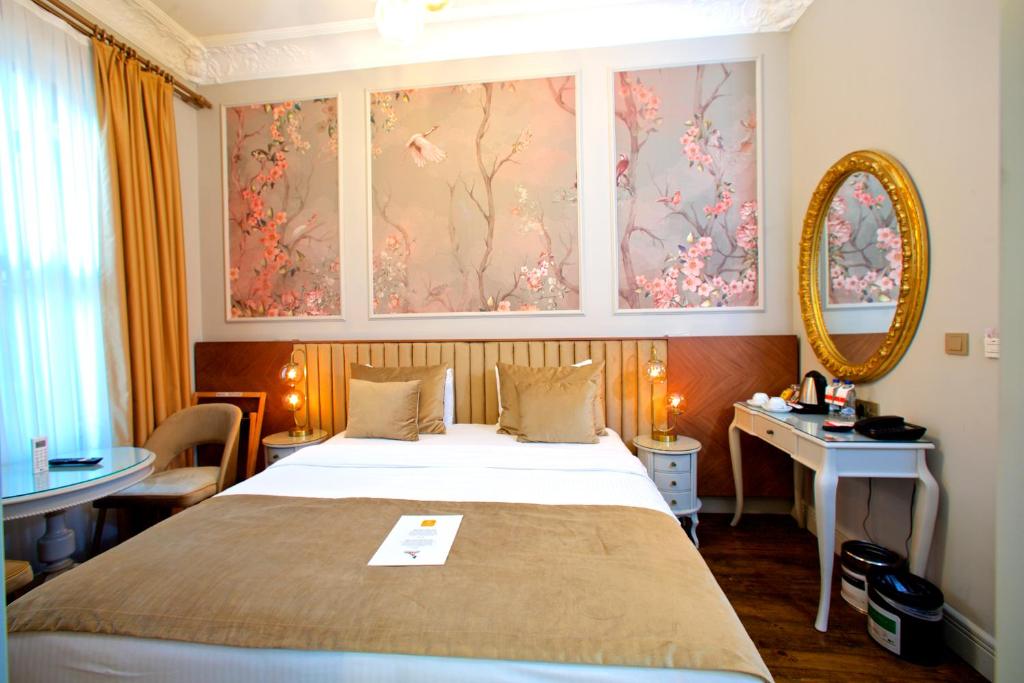 イスタンブールにあるAyramin Exclusive Hotel - Special Categoryのベッドと机と鏡のある寝室