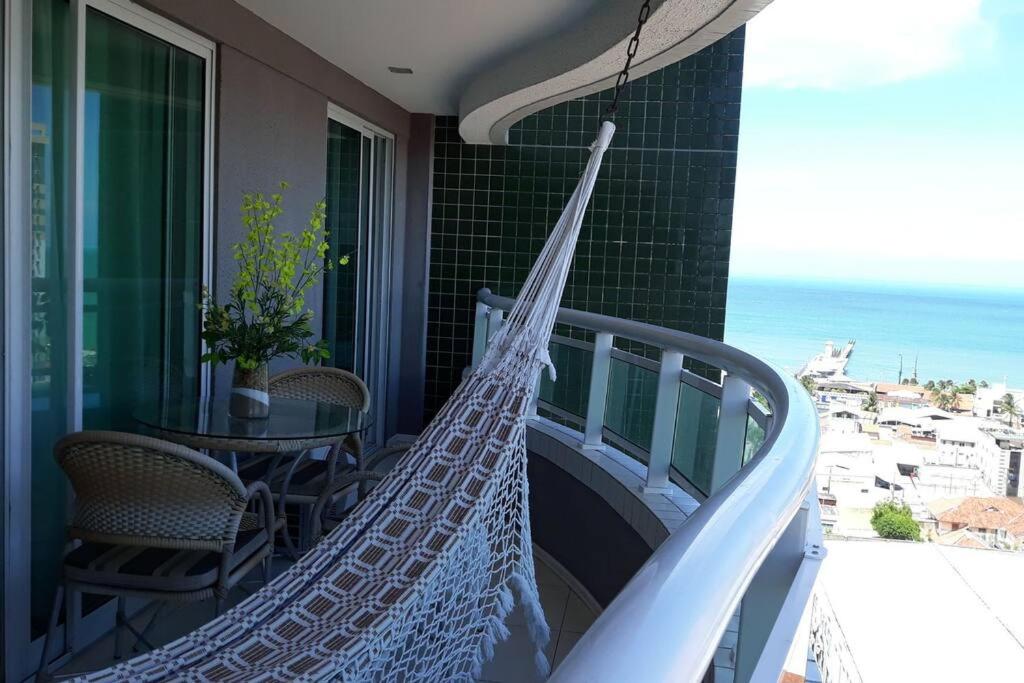 uma rede de descanso numa varanda com vista para o oceano em Cantinho de Iracema em Fortaleza