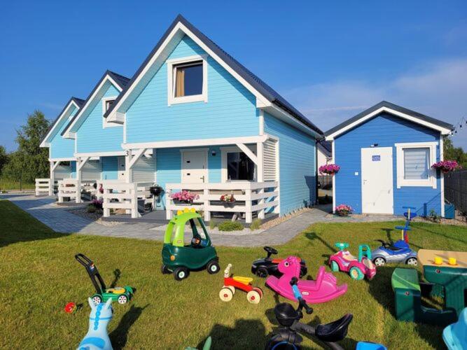 a blue house with toy vehicles in front of it at Comfortable holiday homes for 7 people, Niechorze in Niechorze