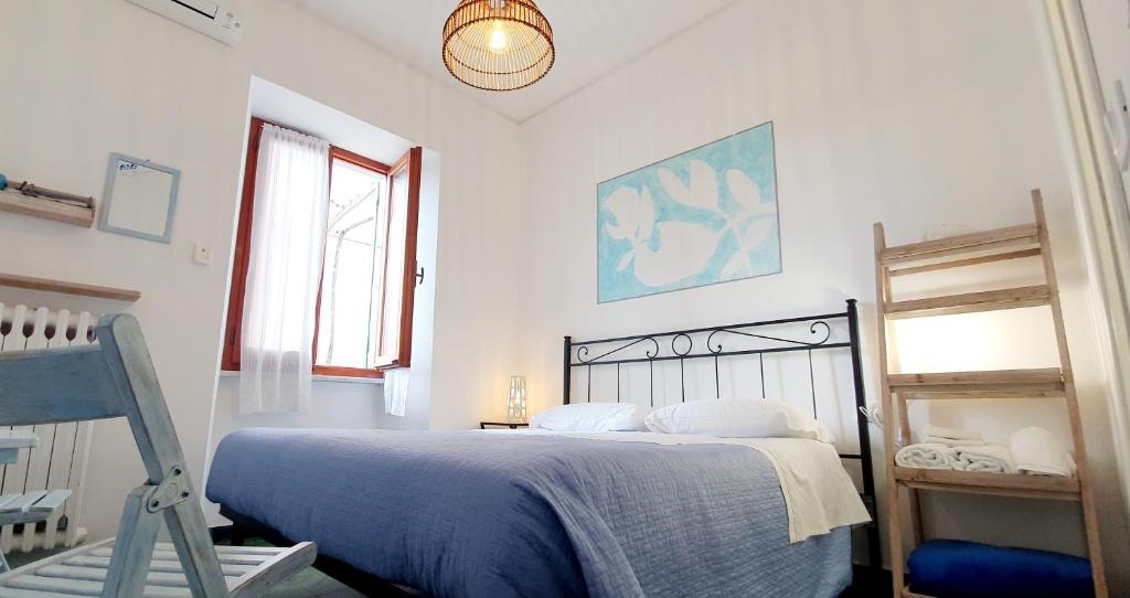 a bedroom with a bed with a blue blanket at Arbanella in Corniglia