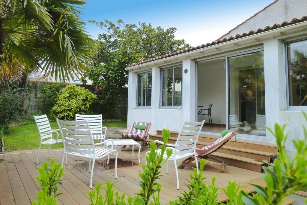 un groupe de chaises et de tables sur une terrasse dans l'établissement Holiday Home in Vendee near Sandy Beaches, à Les Sables-dʼOlonne