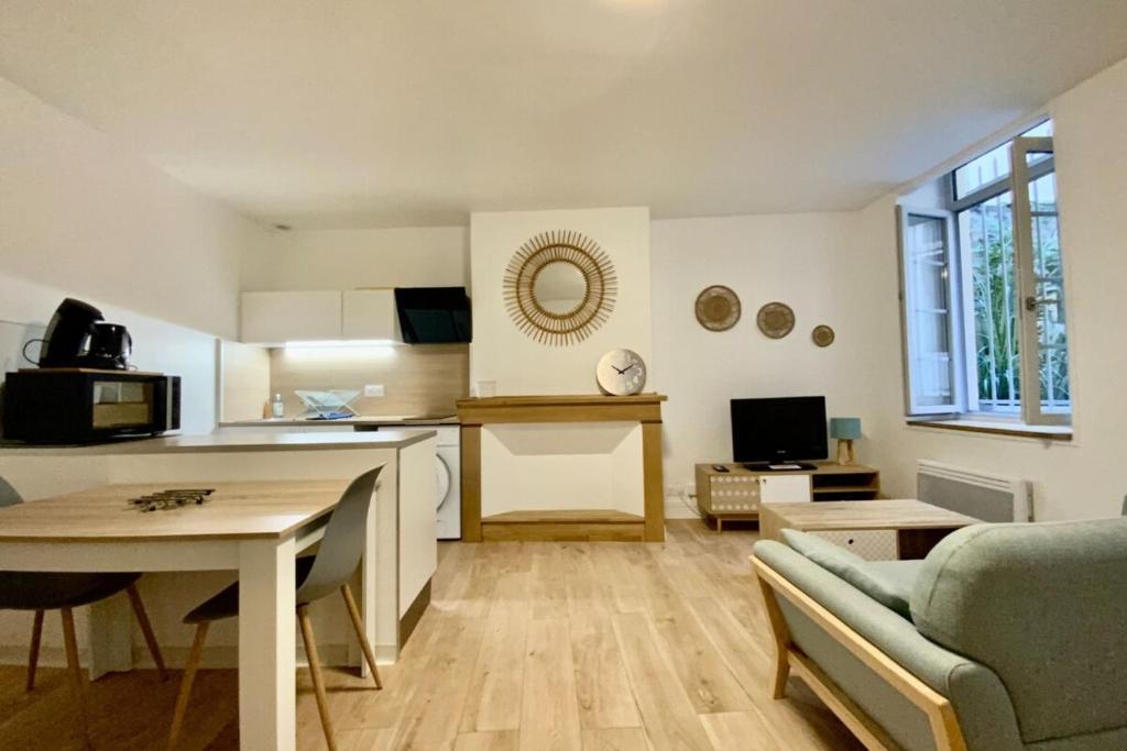 une cuisine et un salon avec une table et un canapé dans l'établissement Le Jeu de Paume - T2 in the city center!, à Montpellier