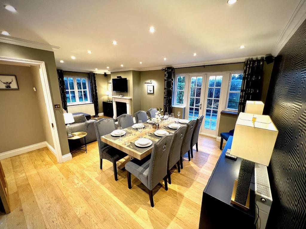 een eetkamer met een lange tafel en stoelen bij Honey Hill Cottage - 4 Bedroom Detached House in Cambridge