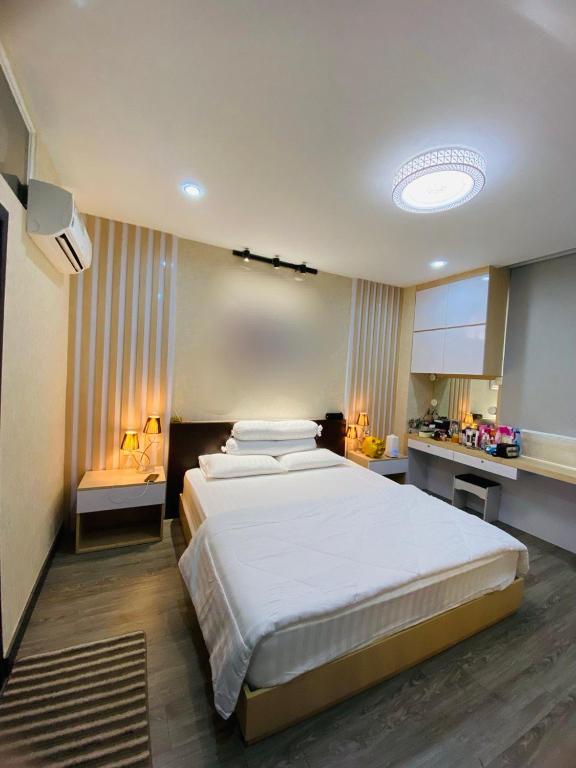 Condo Begonia Sen Sok Town في بنوم بنه: غرفة نوم مع سرير أبيض كبير في غرفة