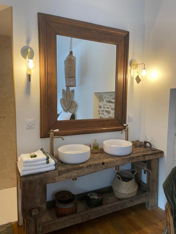 a bathroom with two sinks and a mirror at La Petite Grange - Spa Balnéo in Vigneux-de-Bretagne