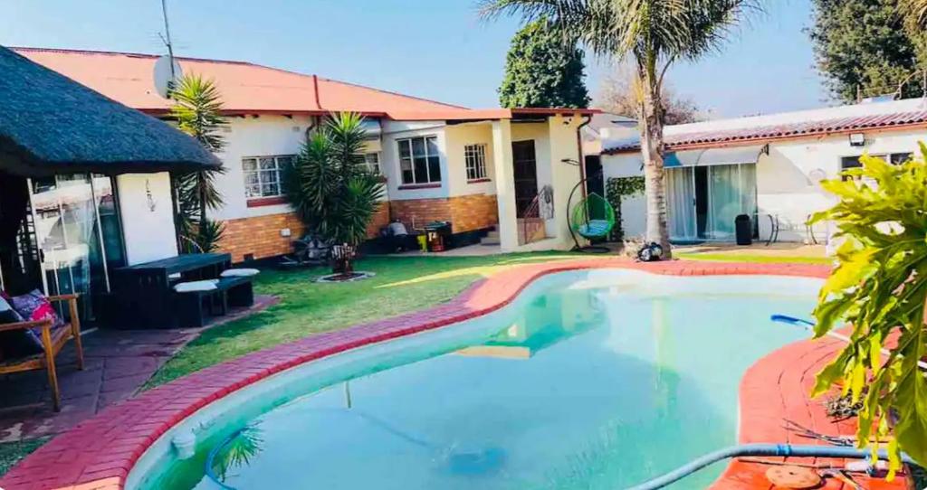 ein Swimmingpool vor einem Haus in der Unterkunft Terrys Cozy Homestay in Germiston
