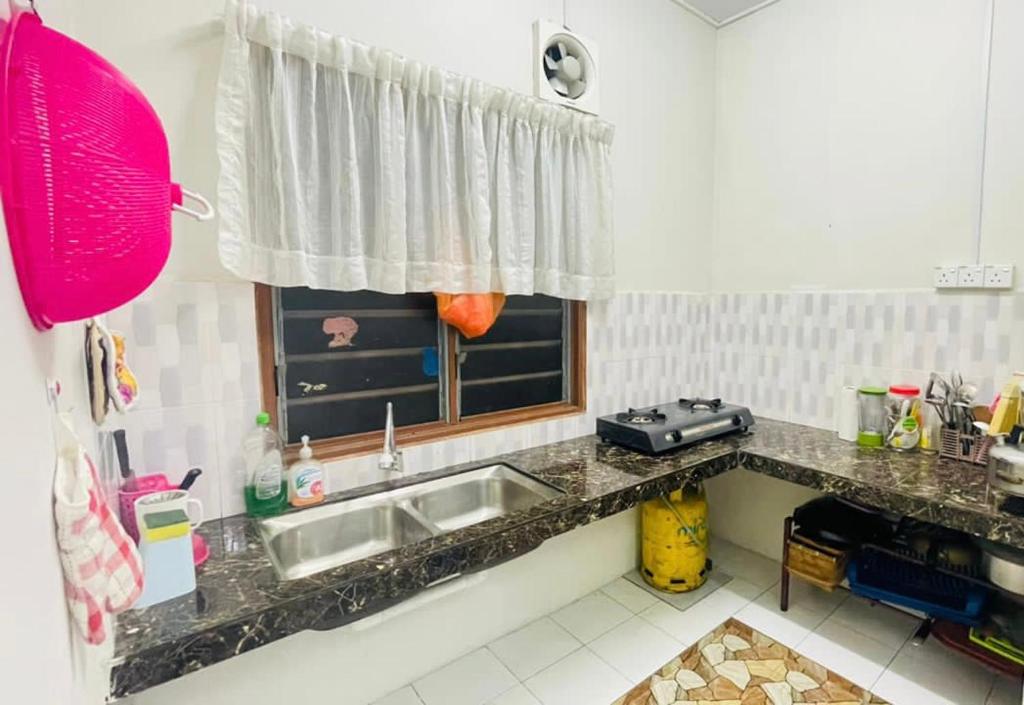 a kitchen with a sink and a window at Homestay Port Dickson in Port Dickson