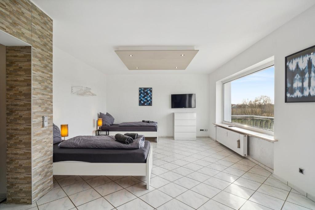 a bedroom with two beds and a large window at SU01 Wohnung in Klein-Gerau! in Büttelborn
