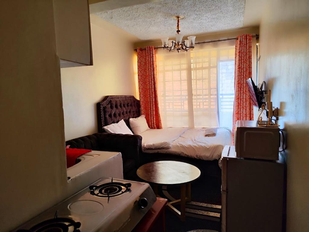 Habitación pequeña con cama y sofá en Travelers staycation - 15 Mins to Westlands en Kikuyu