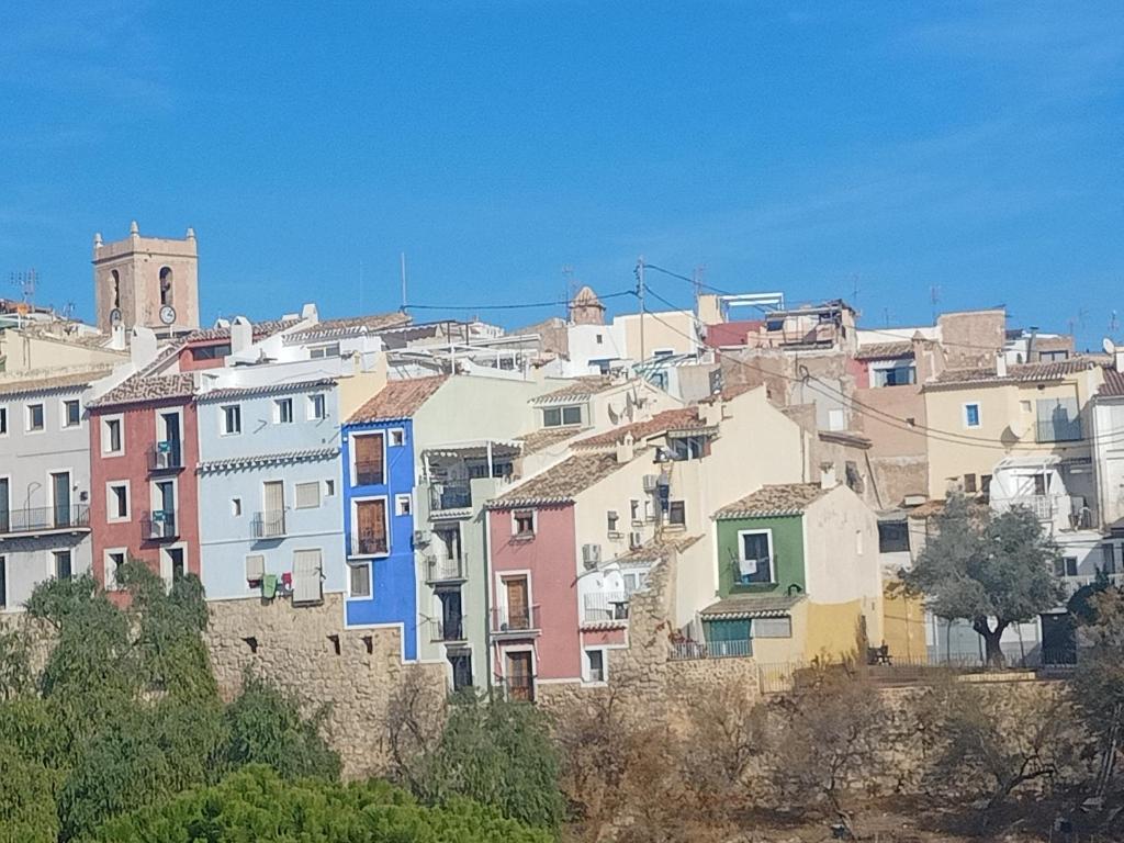 a group of houses on a hill with a clock tower at Piso junto al mar de 80m² in Villajoyosa