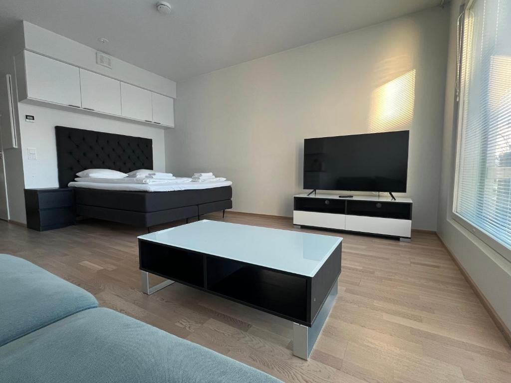 a living room with a couch and a flat screen tv at Simple studio for two in Turku Center in Turku