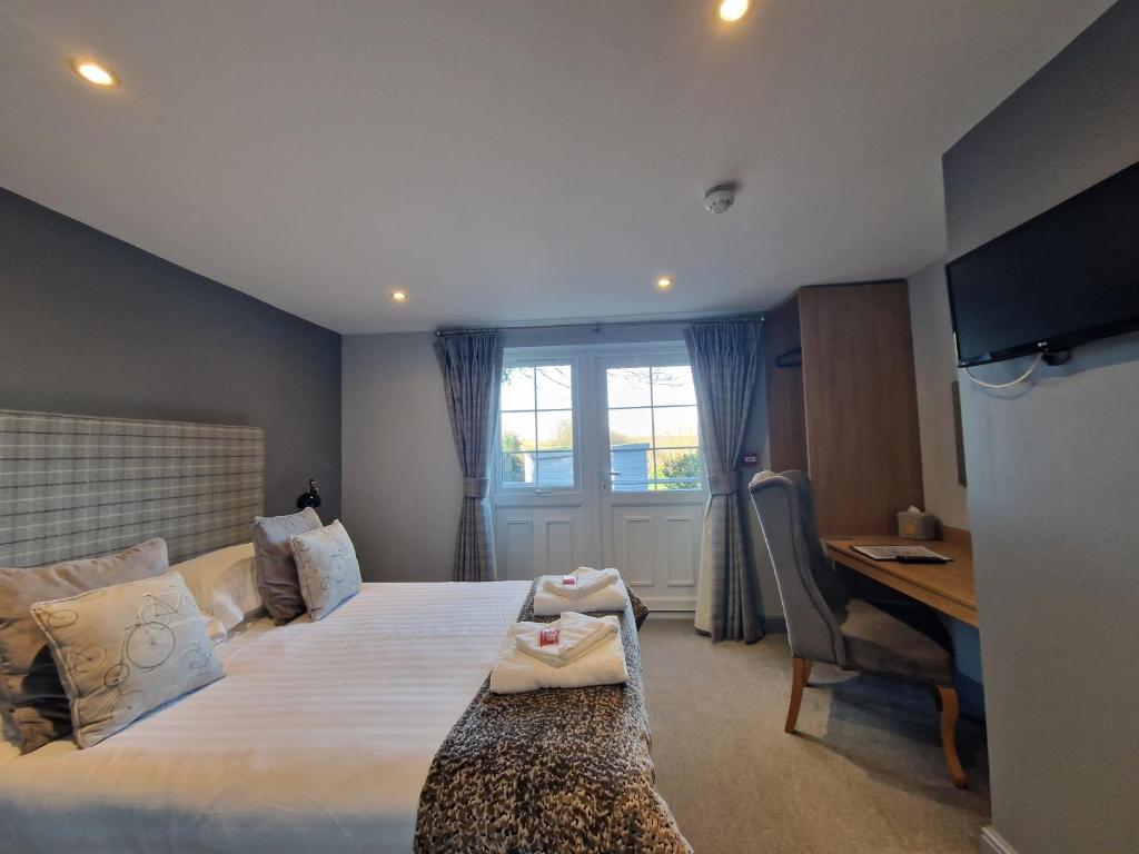 a bedroom with a bed and a desk and a window at The Star in West Leake