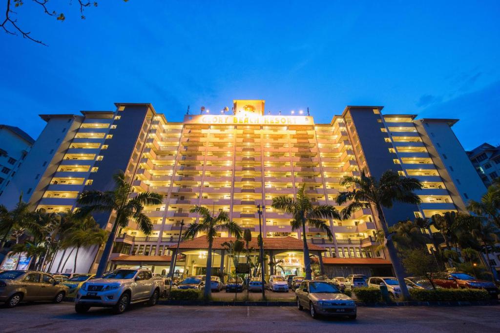 duży hotel z samochodami zaparkowanymi na parkingu w obiekcie 3 BEDROOM SEAVIEW CONDO @ GLORY BEACH RESORT, PORT DICKSON w mieście Port Dickson