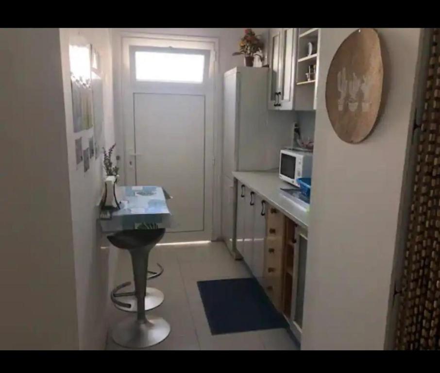 a small kitchen with a table and a refrigerator at My House Urban in Arrecife