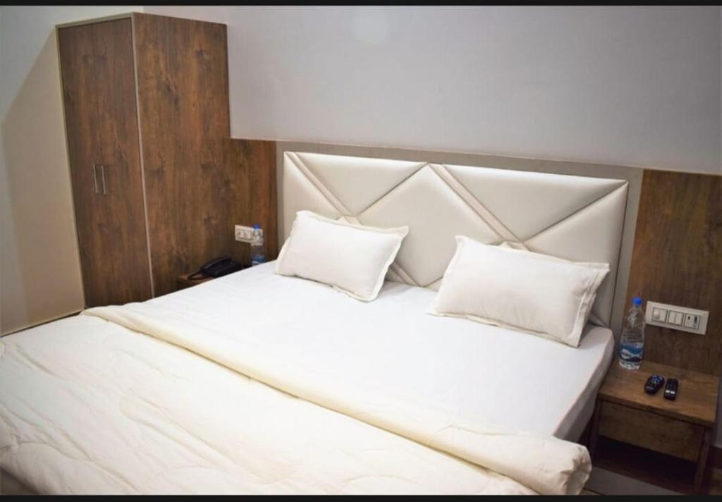 ein großes weißes Bett mit zwei Kissen darauf in der Unterkunft Moms Hostel in Agra