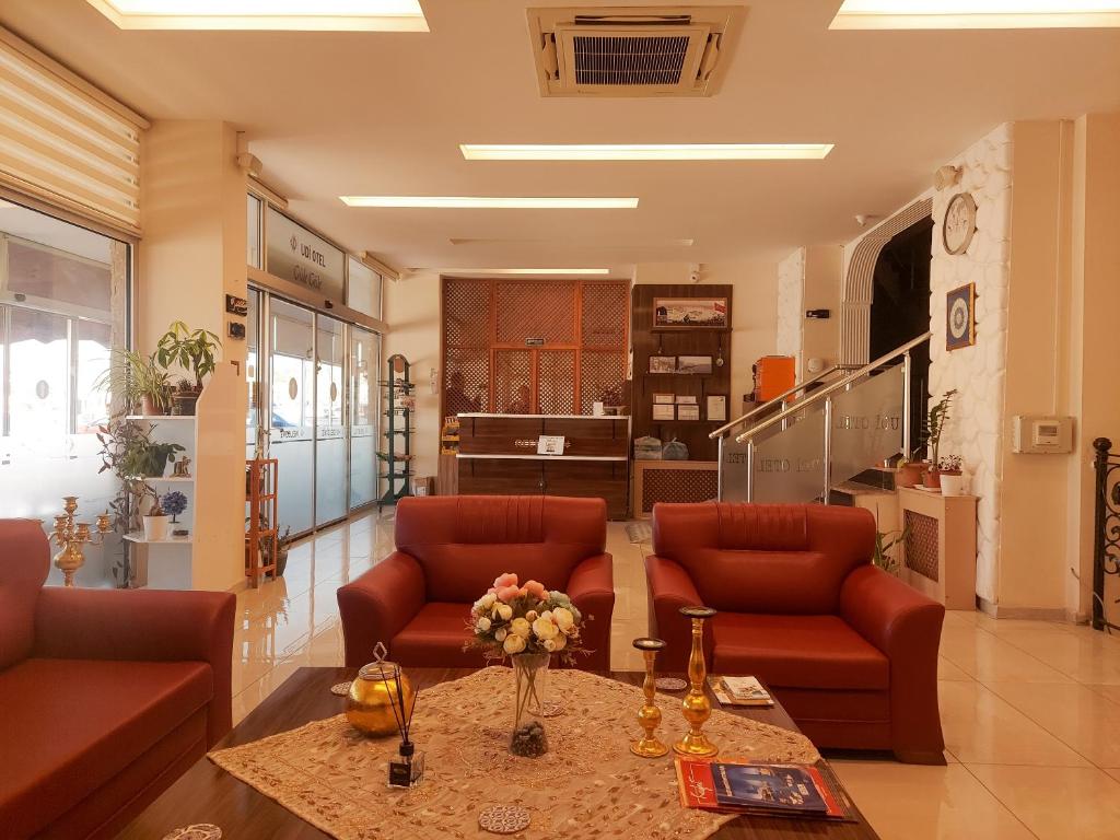 a lobby with two red chairs and a table at Udi Hotel in Canakkale