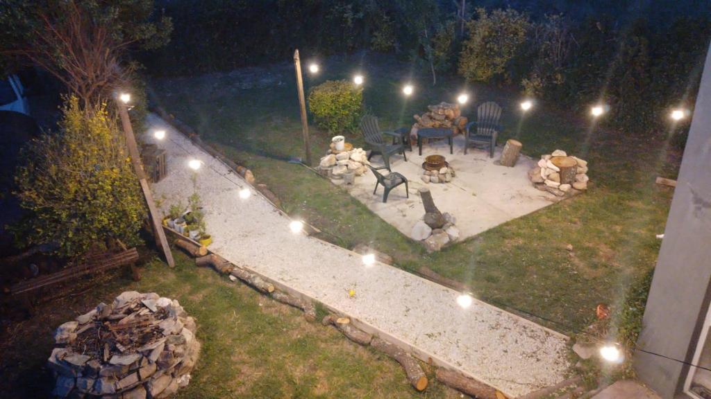 um quintal com uma mesa e cadeiras à noite em Casa de Playa en Chapadmalal em Chapadmalal