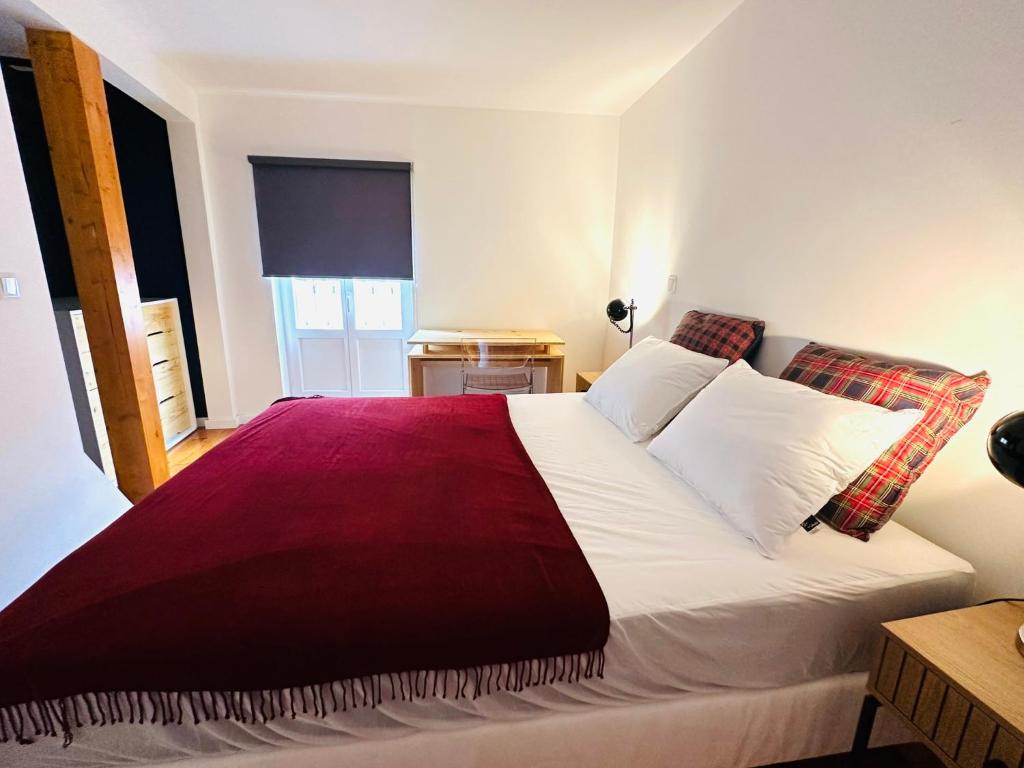 sypialnia z dużym łóżkiem i czerwonym kocem w obiekcie Castle cozy apartment w Lizbonie