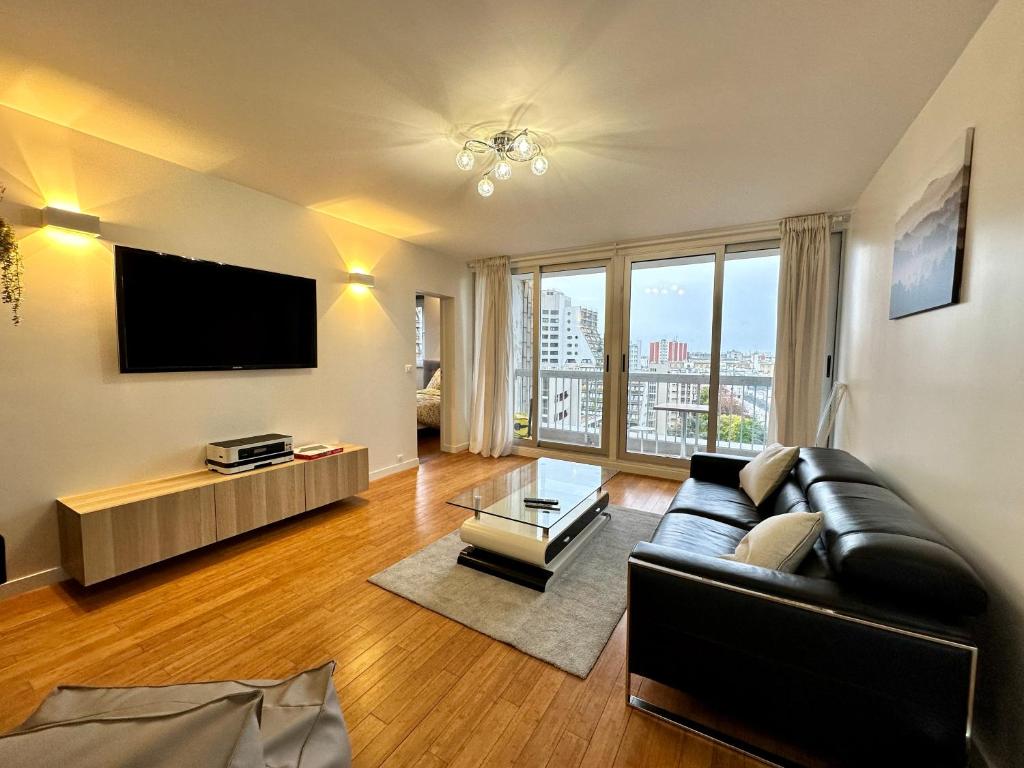 un salon avec un canapé et une télévision dans l'établissement Superb modern and spacious apartment Mathis, à Paris