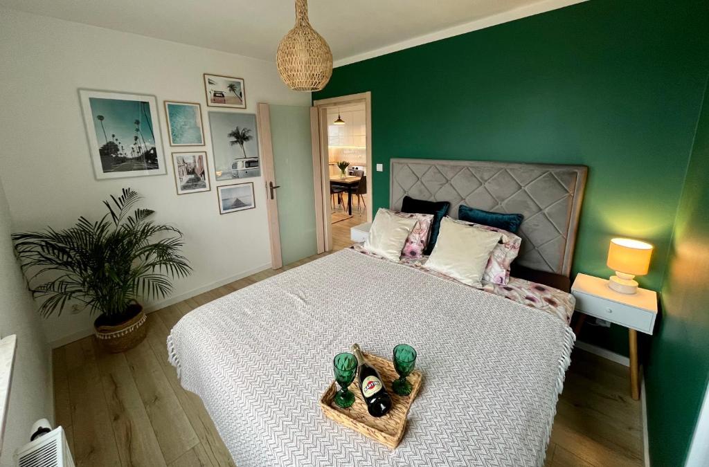 a bedroom with a large bed with a green wall at Przytulna Apartment close to the airport and PKM in Gdańsk
