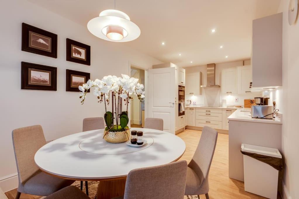 eine Küche und ein Esszimmer mit einem Tisch und Stühlen in der Unterkunft Tranquil 4-Bed Oasis Modern Chic House in Oxford