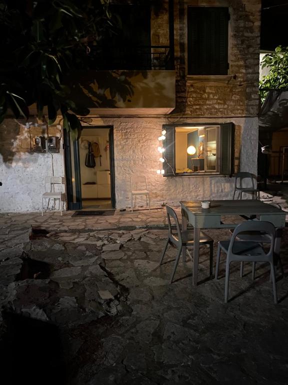 ナフパクトスにあるΣπιτικό στη Ναύπακτοの夜間の建物前のテーブルと椅子