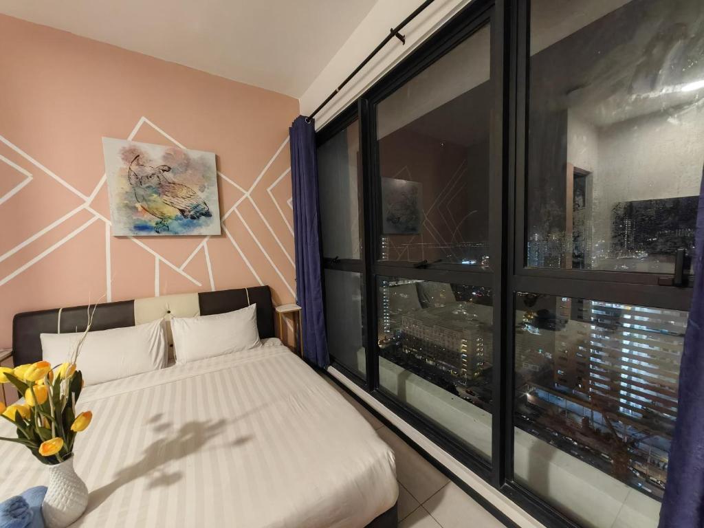 ein Schlafzimmer mit einem Bett und einem großen Fenster in der Unterkunft Jazz family homestay in Jelutong