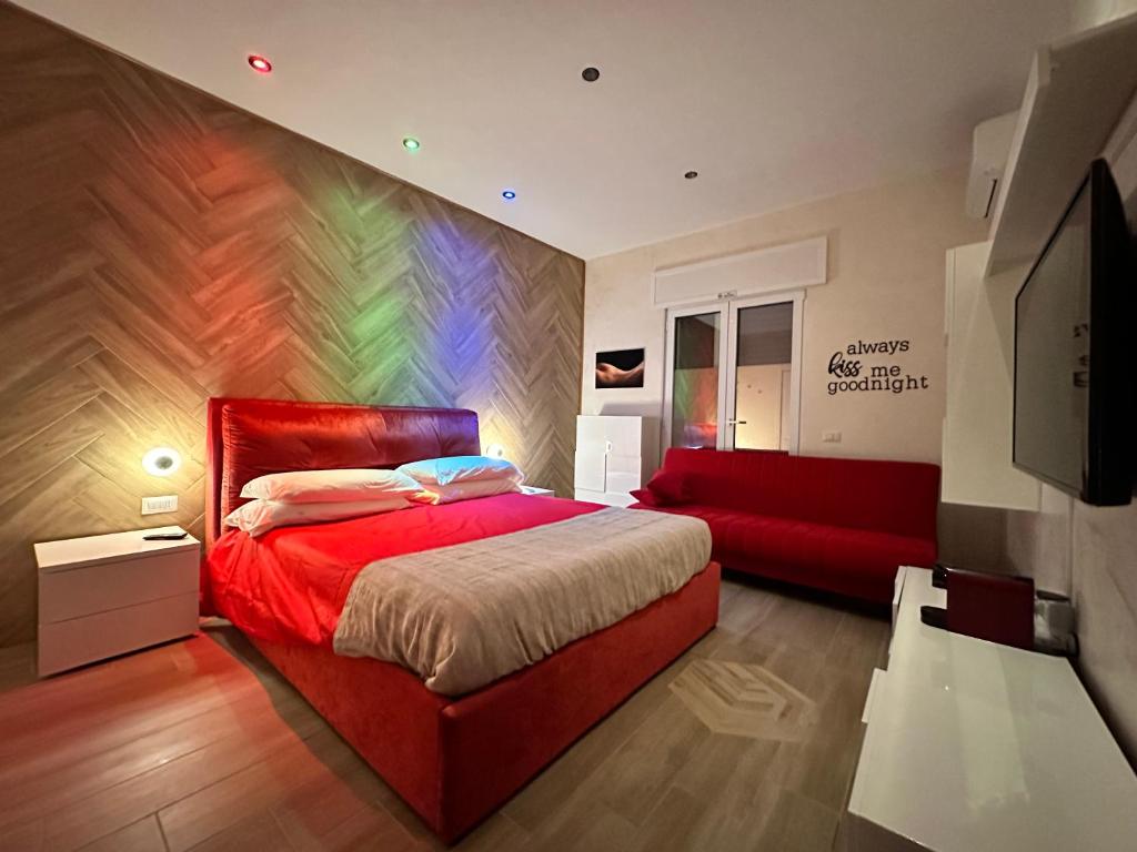 a bedroom with a red bed and a red couch at Othalan Home in Paestum