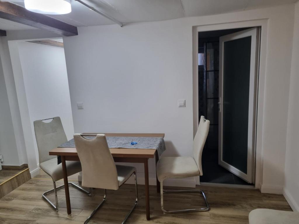 a dining room with a wooden table and chairs at Garage studio in Bistriţa