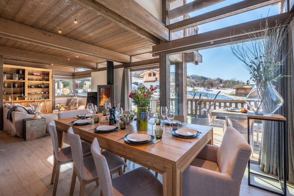 une salle à manger avec une table et des chaises et une grande fenêtre dans l'établissement Chalet Satine - Luxe au pied des pistes, à Demi-Quartier