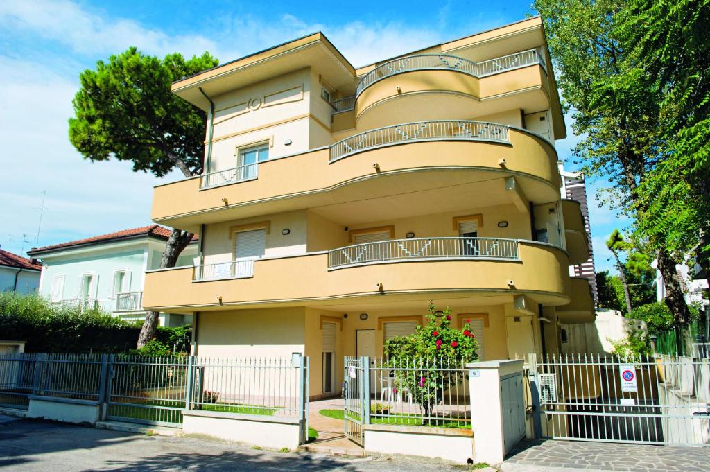 een geel gebouw met een hek ervoor bij Residenza Raggio in Riccione
