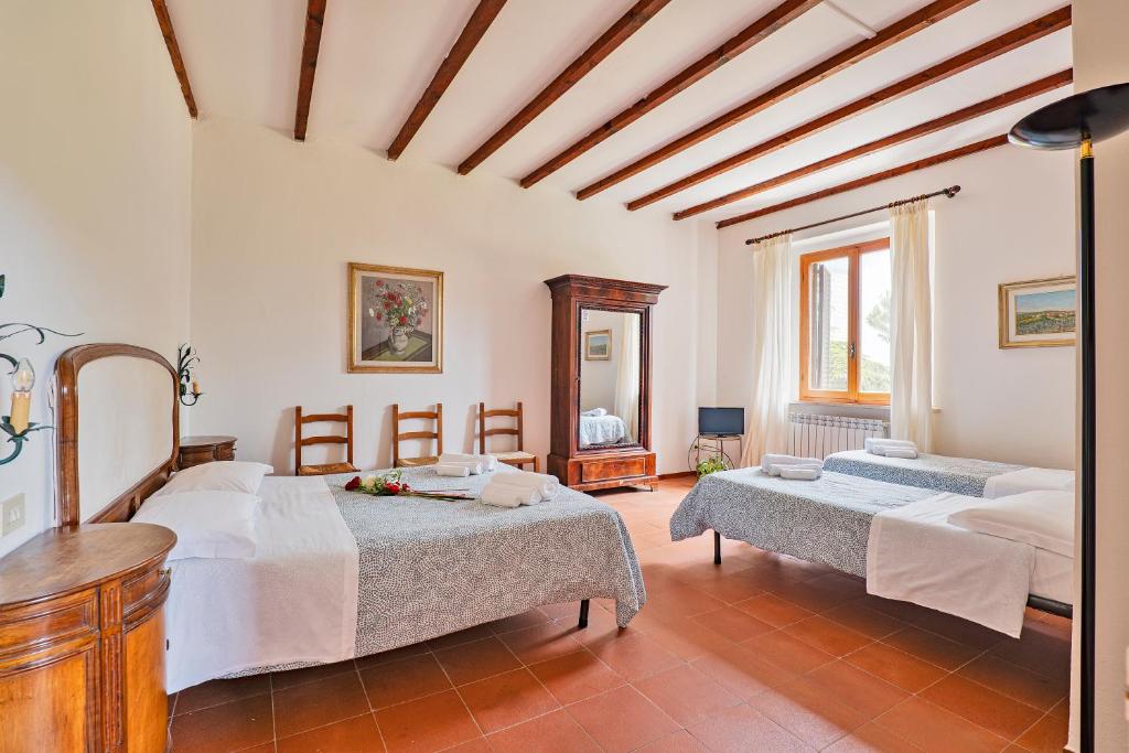 1 dormitorio con 2 camas y espejo en Casalchino-Fattoria La Torre, en San Gimignano