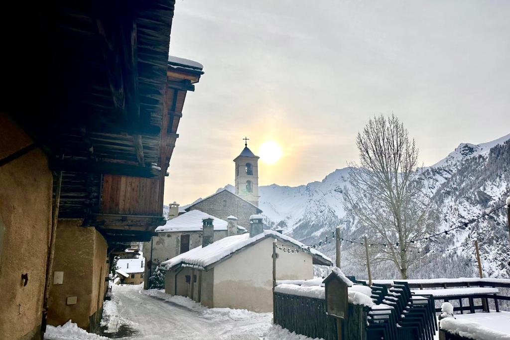聖韋朗的住宿－CASA-La Fuste center St-Véran foot of the slopes 6p，一座小镇,有教堂和一条雪覆盖的街道