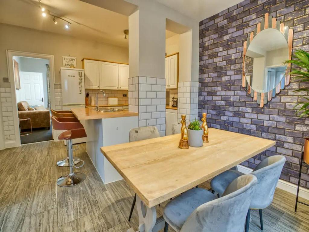 una cucina e una sala da pranzo con tavolo e sedie in legno di Pass the Keys Large Family House near Lincoln a North Hykeham