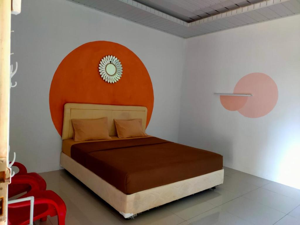 Schlafzimmer mit einem Bett mit einem orangefarbenen Kopfteil in der Unterkunft Sarah's Cottage Toba Samosir in Tuk Tuk