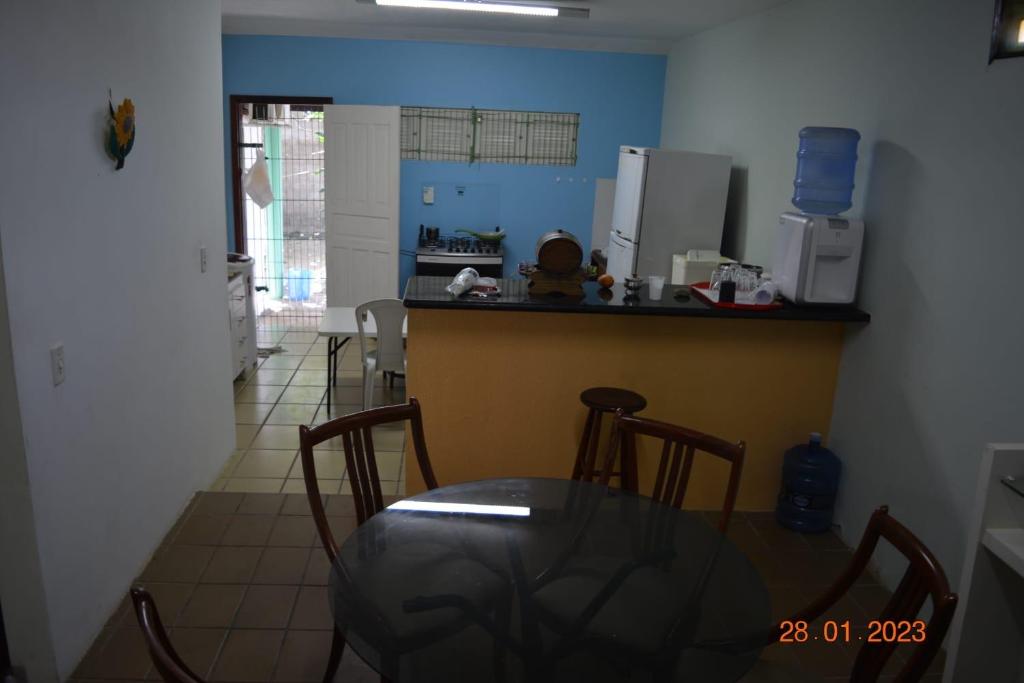 a kitchen with a glass table and a counter top at Casa Coqueiro in Luis Correia